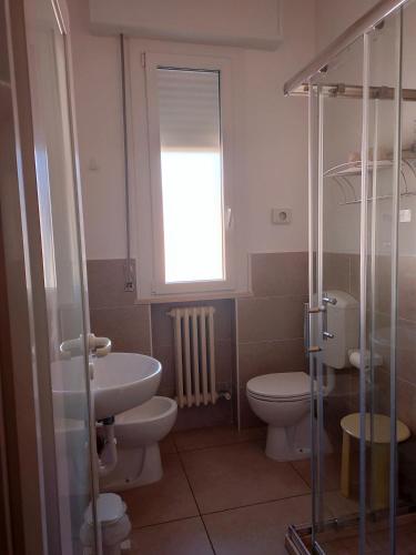a bathroom with two toilets and a sink and a window at B&b villa lambusta in Cesenatico