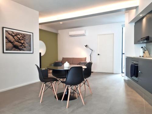 a kitchen and dining room with a table and chairs at Lesplanade By Wynwood House in Panama City