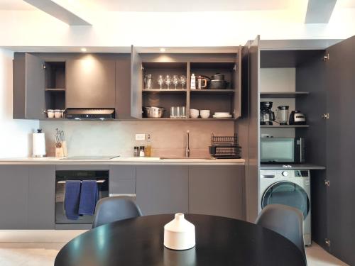 a kitchen with a black table and chairs and a sink at Lesplanade By Wynwood House in Panama City
