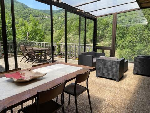 une terrasse avec une table et des chaises en bois. dans l'établissement Maison typique ardéchoise et sa rivière privée, à La Celle-sous-Gouzon