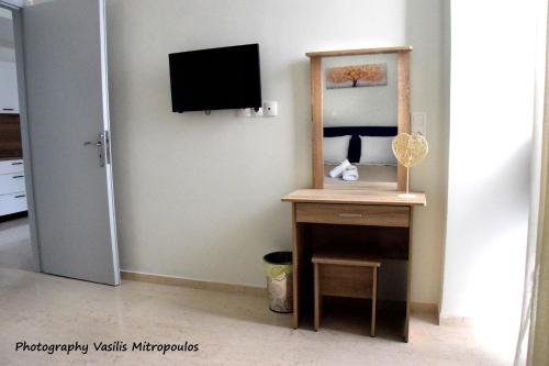 a room with a television and a table with a mirror at Comfort Holidays in Messini