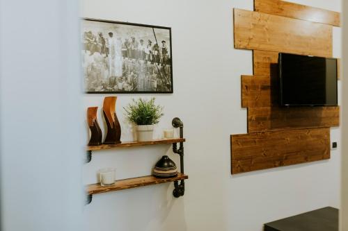 een woonkamer met een tv en houten planken bij Loft 291 in Matera