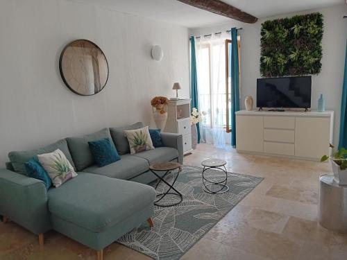 un salon avec un canapé et une télévision dans l'établissement Maison de village entièrement rénovée avec goût, à Sillans-la-Cascade