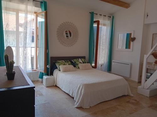 une chambre avec un lit et une grande fenêtre dans l'établissement Maison de village entièrement rénovée avec goût, à Sillans-la-Cascade