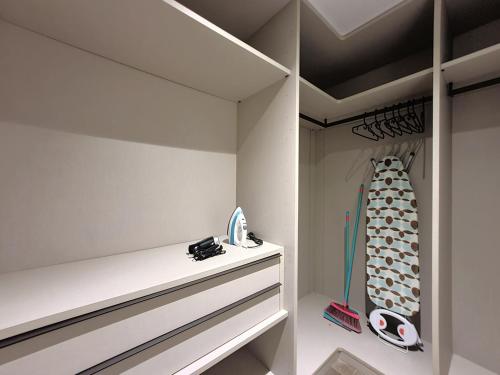 a walk in closet with white walls and a white dresser at Lesplanade By Wynwood House in Panama City