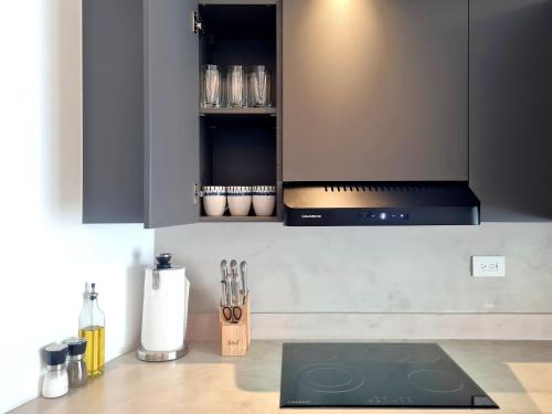 a kitchen with black cabinets and a stove top oven at Lesplanade By Wynwood House in Panama City