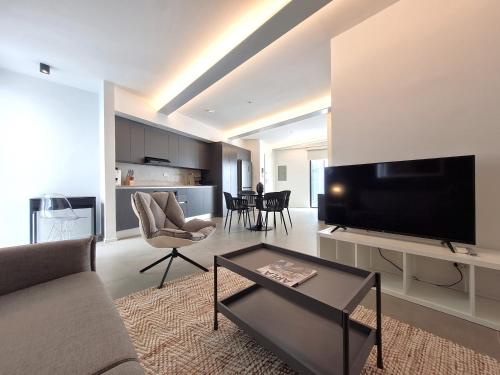 a living room with a couch and a tv at Lesplanade By Wynwood House in Panama City