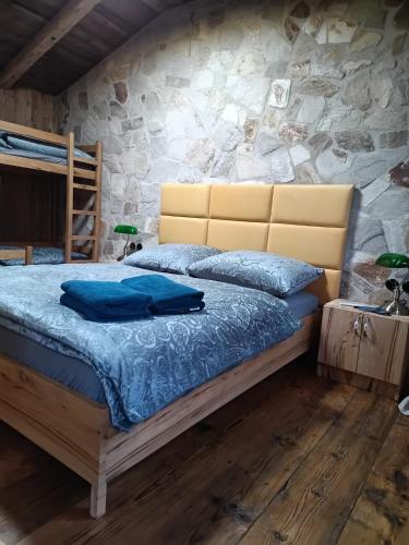 a bedroom with a bed and a stone wall at WoodhouseOld in Červená Voda