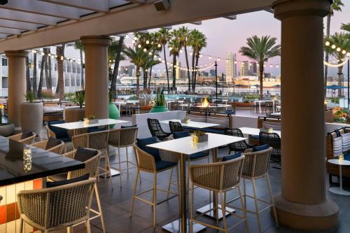 a restaurant with tables and chairs and palm trees at Coronado Island Marriott Resort & Spa in San Diego