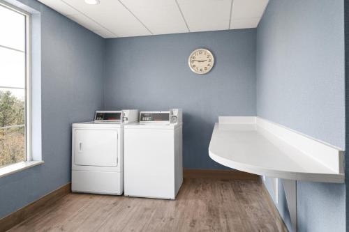 a laundry room with a washer and dryer and a clock at Holiday Inn Express & Suites Aiken by IHG in Aiken