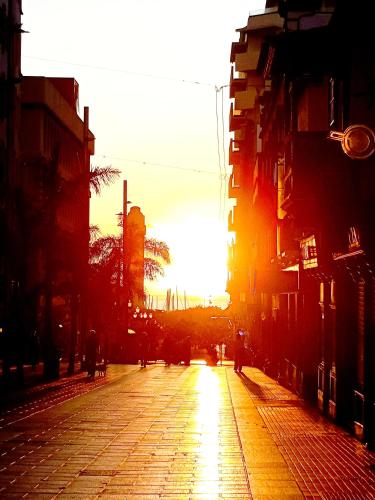 an empty street with the sun setting in the distance at Casapatrizia Appartamento compartido in Santa Cruz de Tenerife