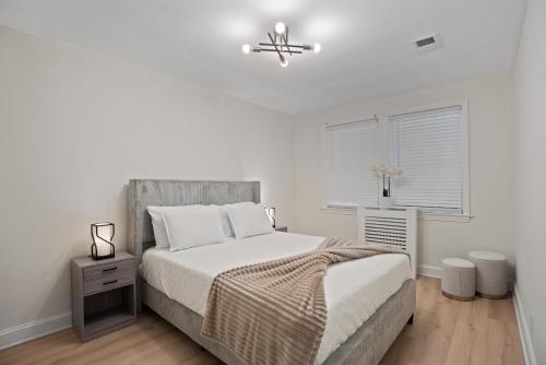 a white bedroom with a bed and a ceiling fan at The Cozy District Den Stay in Washington