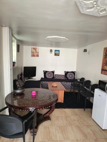 un salon avec une table et un canapé dans l'établissement Joli Appart indépendant dans le calme, à Épinay-sur-Seine