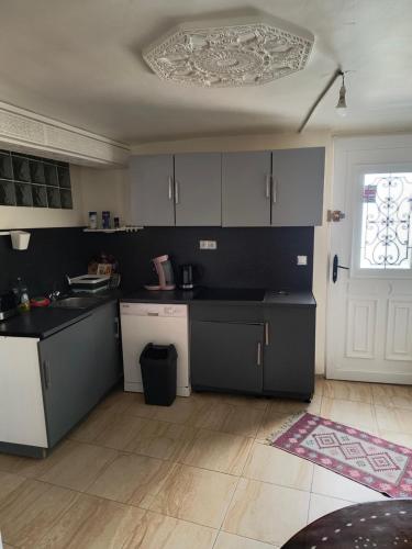 une cuisine avec comptoirs en noir et blanc et une fenêtre dans l'établissement Joli Appart indépendant dans le calme, à Épinay-sur-Seine