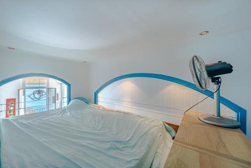 Cette chambre comprend un lit avec un ventilateur et une table. dans l'établissement Panoramic Sea View - Promenade des Anglais, à Nice