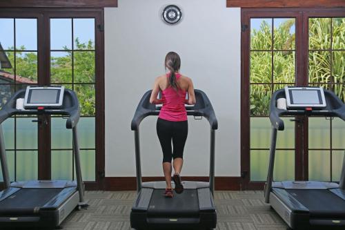 a woman walking on a treadmill in a gym at JW Marriott Guanacaste Resort & Spa in Tamarindo