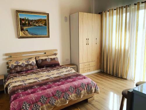 a bedroom with a bed and a large window at Pogradec Lake Apartments in Pogradec