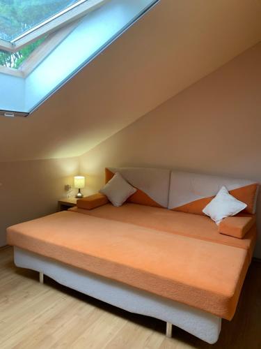 ein Schlafzimmer mit einem großen Bett mit Dachfenster in der Unterkunft INDI Apartman Siófok in Siófok