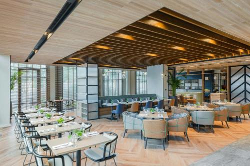 a dining room with tables and chairs and windows at Four Points by Sheraton King Abdulaziz Road in Riyadh