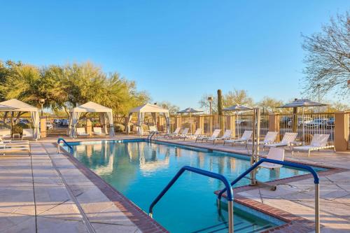 a swimming pool with a bunch of chairs around it at Residence Inn Phoenix Desert View at Mayo Clinic in Phoenix