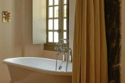 a bath tub in a bathroom with a window at Hôtel du Couvent, a Luxury Collection Hotel, Nice in Nice