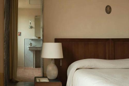 a bedroom with a bed and a lamp on a table at Hôtel du Couvent, a Luxury Collection Hotel, Nice in Nice