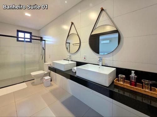 a bathroom with two sinks and a mirror at 2 Suítes Novas Alto padrão Área de Lazer Ampla in Foz do Iguaçu