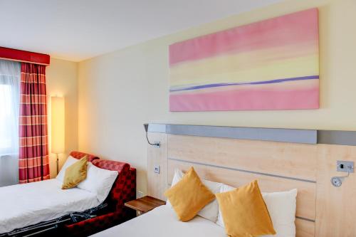 a hotel room with two beds and a painting on the wall at Belvilla Aberdeen Bridge of Don Sea View in Aberdeen