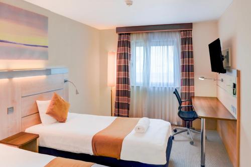 a hotel room with two beds and a desk at Belvilla Aberdeen Bridge of Don Sea View in Aberdeen