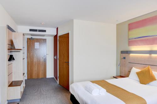 a bedroom with two beds and a colorful painting on the wall at Belvilla Aberdeen Bridge of Don Sea View in Aberdeen