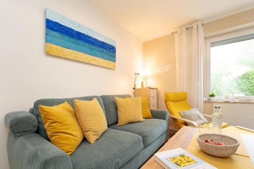 a living room with a blue couch and yellow pillows at Wiesenredder 6 in Lenste