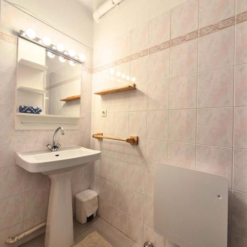 une salle de bain avec un lavabo, des toilettes et un miroir dans l'établissement L'ECUME - Logement les pieds dans le sable, à Mauguio