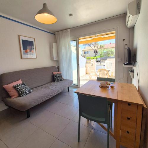 un salon avec un canapé et une table dans l'établissement L'ECUME - Logement les pieds dans le sable, à Mauguio