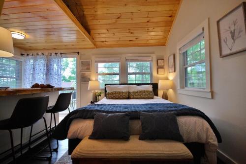 a bedroom with a bed in a room with windows at Cheerful Cottage with Loft Close to Everything 6 in Edgecomb