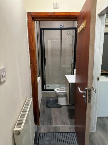 a bathroom with a toilet and a glass shower door at Room 1 in south Yorkshire in Sheffield