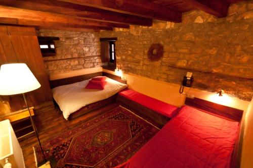 a small bedroom with a bed and a red bench at Arhontiko Aristis in Aristi