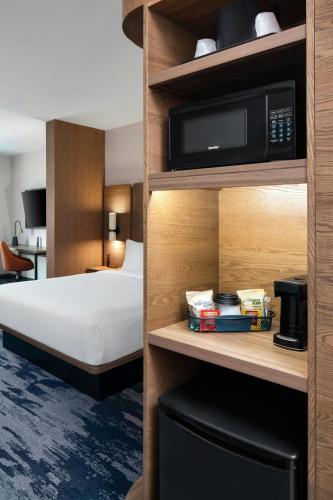a hotel room with a bed and a tv on a shelf at Fairfield by Marriott Inn & Suites Nashville Bellevue in Nashville