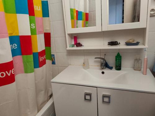 La salle de bains est pourvue d'un lavabo et d'un rideau de douche coloré. dans l'établissement Chambre confortable à 30min de Paris, à Vitry-sur-Seine