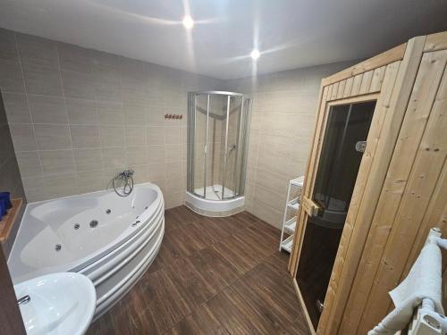 a bathroom with a tub and a sink and a shower at Ski&Sun Apartmán A10 Tatry, Liptovský Mikuláš in Liptovský Mikuláš