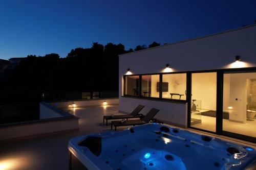 a hot tub on the roof of a house at night at Villa Oasis in Trogir