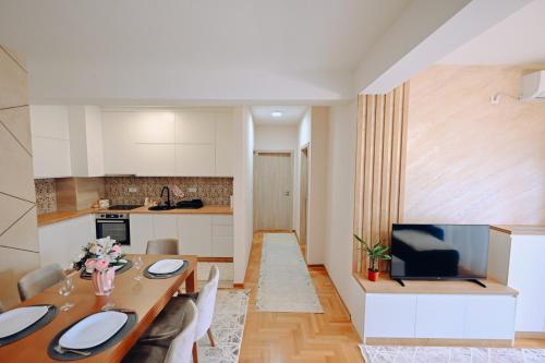 a kitchen and living room with a table and a television at Imperial centar uzice in Užice