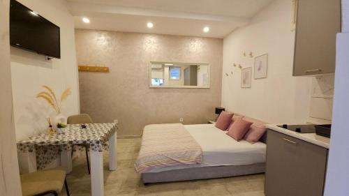 a small bedroom with a bed and a table at Banićević APARTMANI in Ðenovići