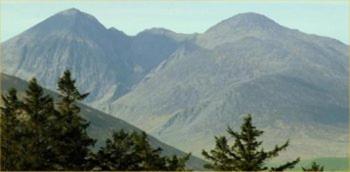 a view of a mountain range with trees in the foreground at Arbutus Lodge in Killarney