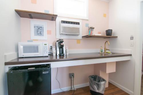 a kitchen with a counter with a microwave and a refrigerator at Ocean House Boutique Hotel & Motel in Old Orchard Beach