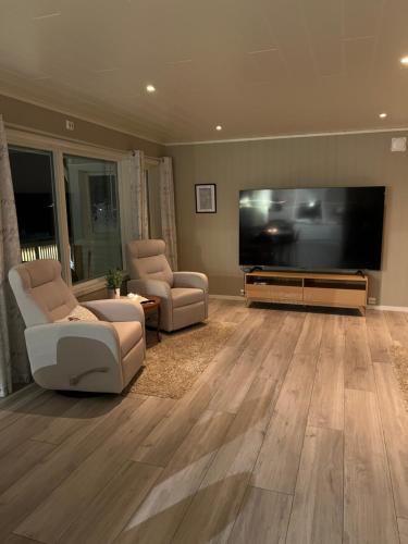 a living room with a large flat screen tv at Huset i Oksfjordhamn in Sandelva