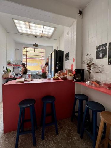 a kitchen with four stools at a counter with people preparing food at Mar de Lava in Mexico City