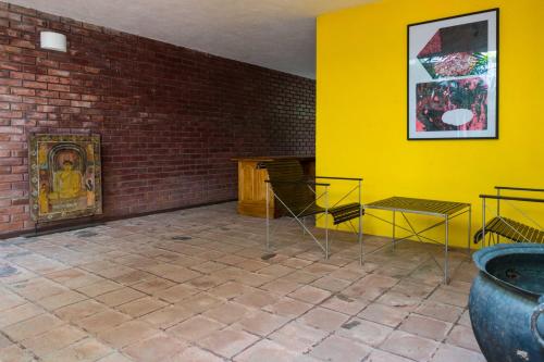 a room with yellow walls and a brick wall at Flower Road Villa in Colombo