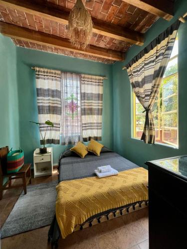 a bedroom with a bed with blue walls and a chandelier at Mar de Lava in Mexico City