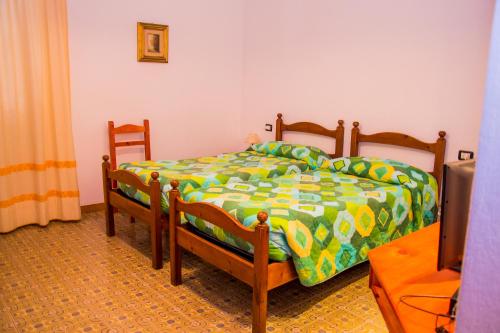 a bedroom with a bed with a green and yellow comforter at Hotel Piccada in Palau