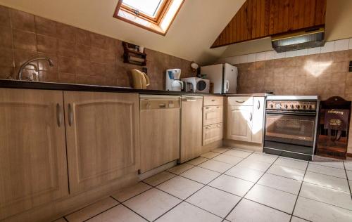 a kitchen with wooden cabinets and white appliances at La Biasou in Gèdre